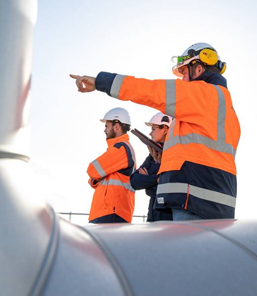 Drei Mitarbeitende von Artelia in Arbeitskleidung auf der Baustelle